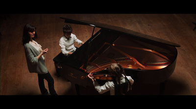 a group of people standing around a piano