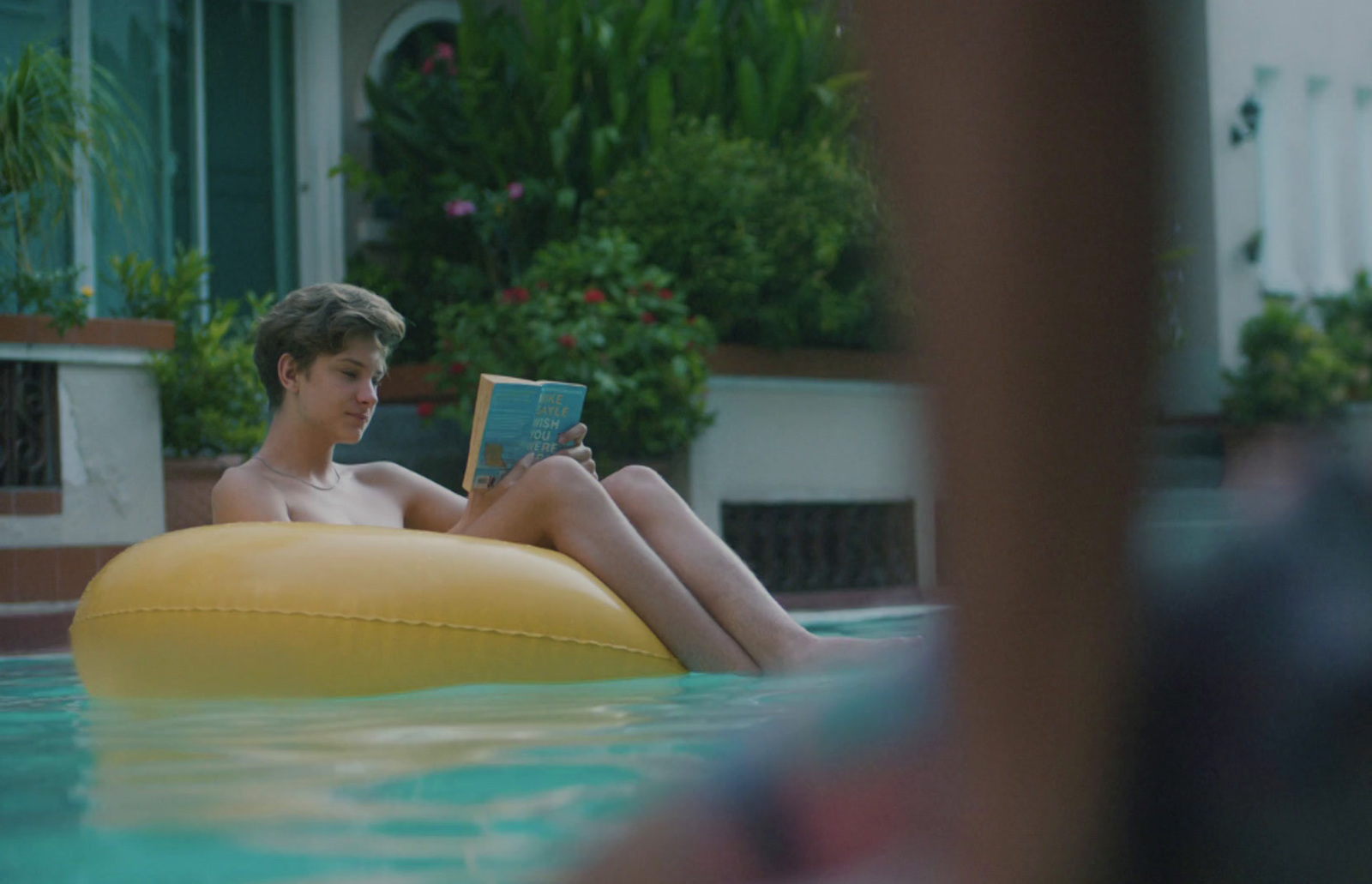 a man sitting in a pool reading a book