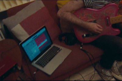 a man sitting on a couch playing a guitar