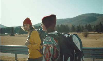 a couple of people that are standing by a fence