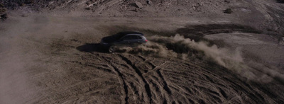 a car is driving through the sand in the desert