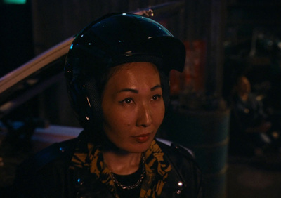 a woman wearing a motorcycle helmet in a dark room