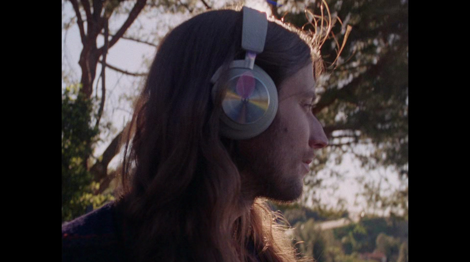 a man with long hair wearing a pair of headphones