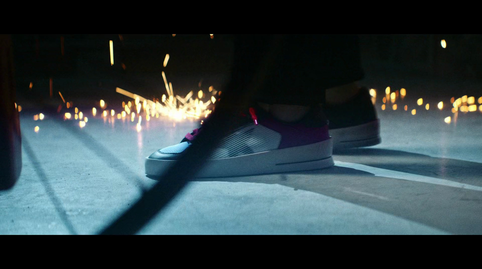 a person standing on a street with their feet on a skateboard