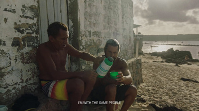 a couple of men sitting next to each other on a beach