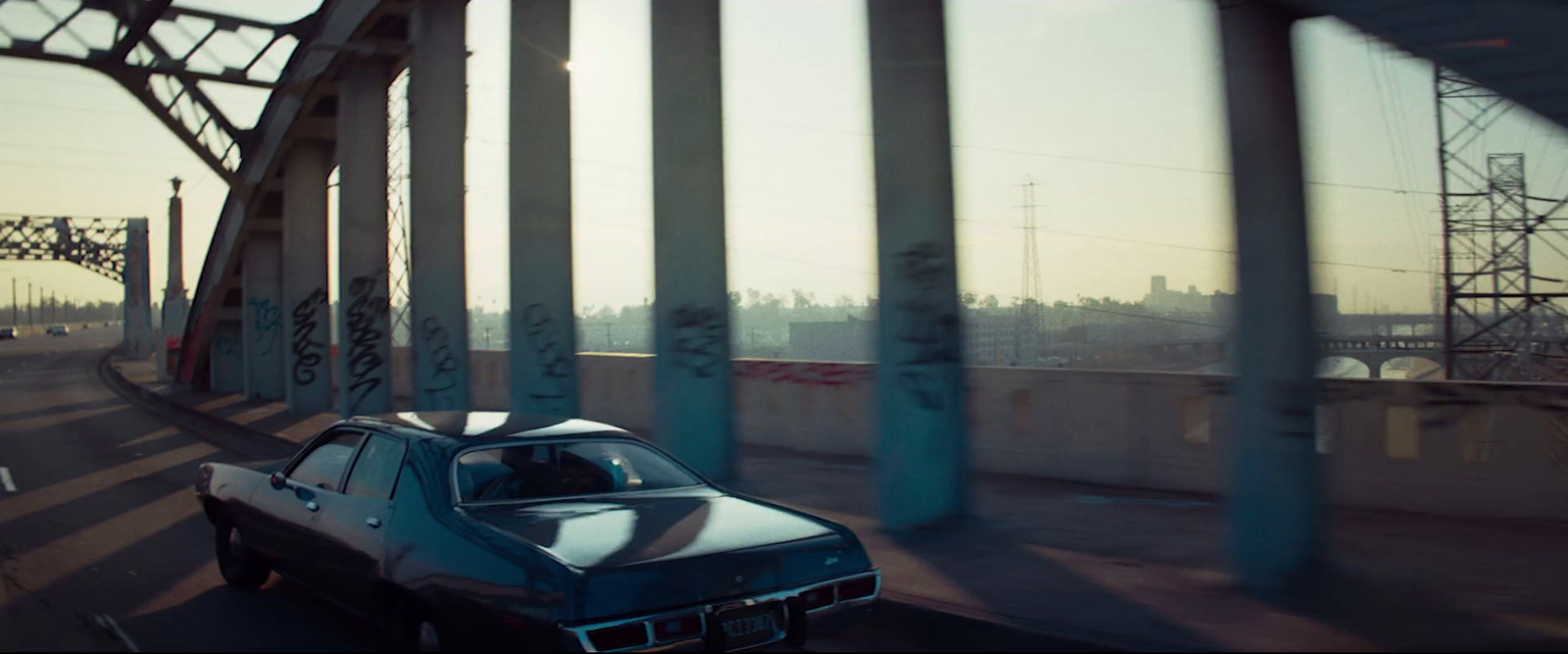 a car driving on a road next to a bridge