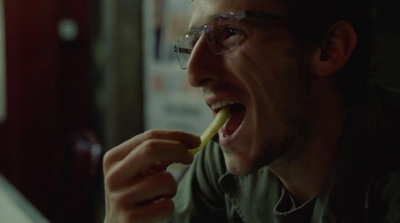 a man with glasses is brushing his teeth