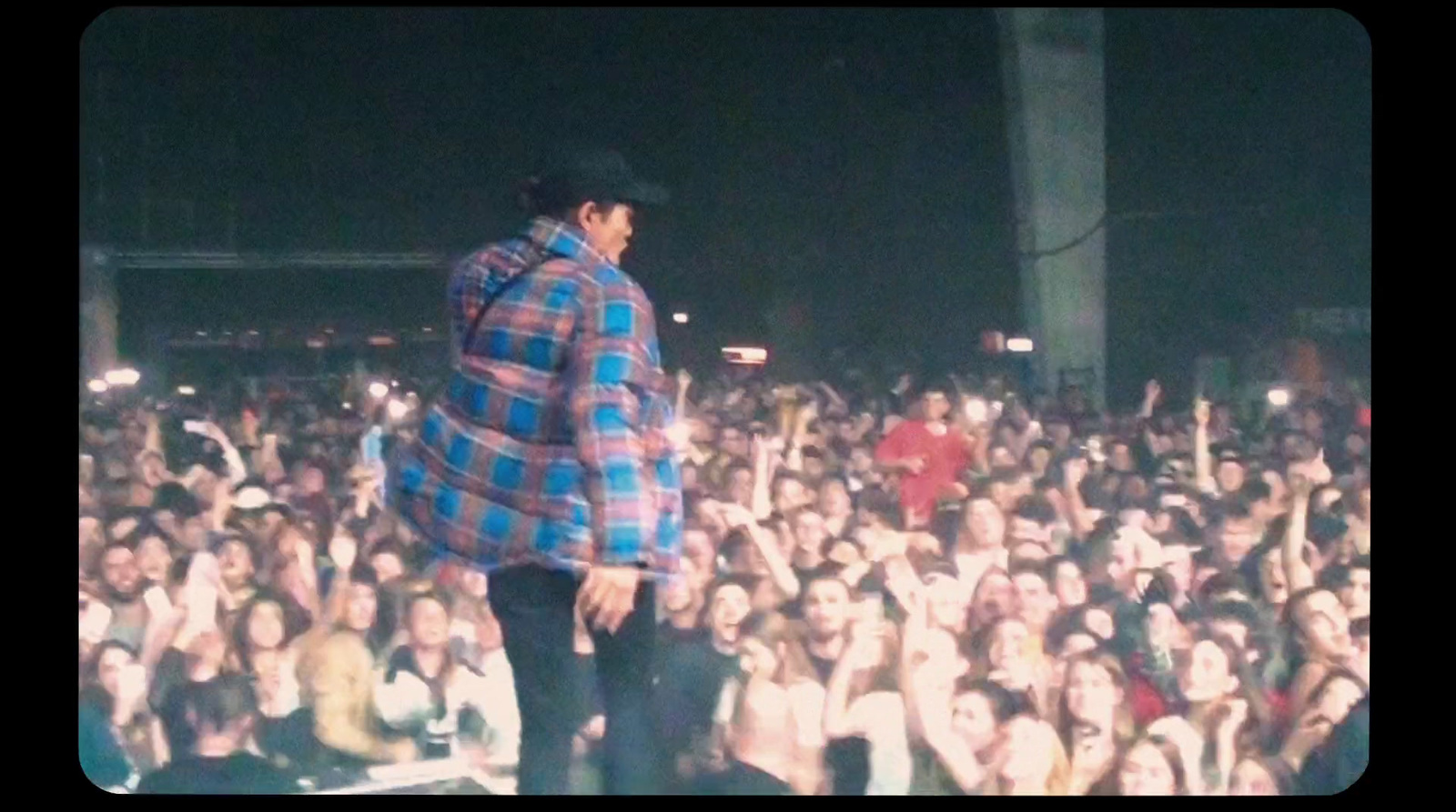 a man standing on top of a stage in front of a crowd