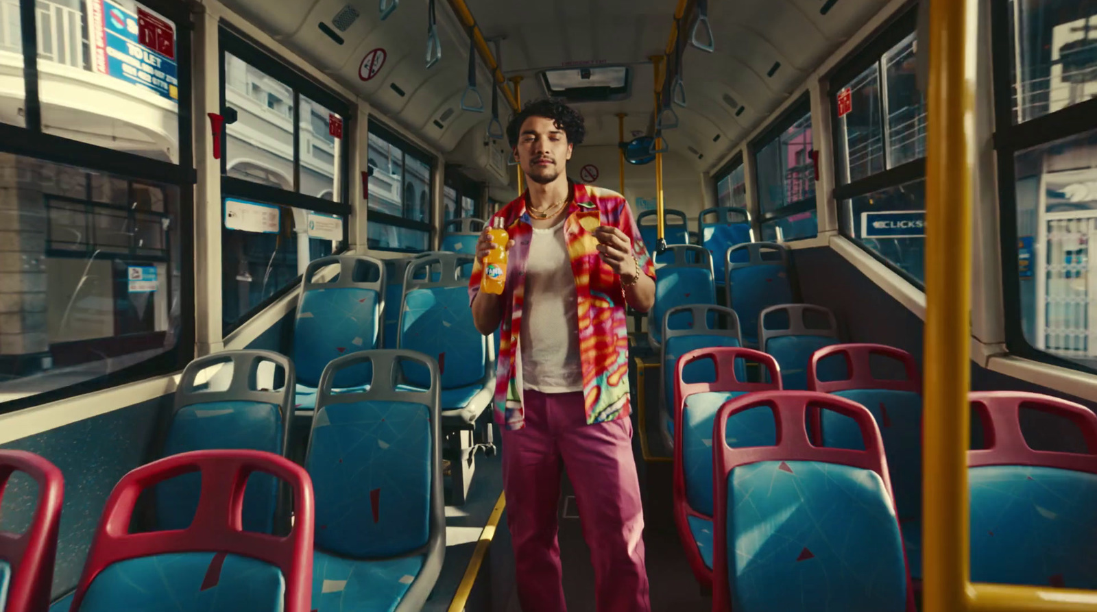 a man standing on a bus looking at his cell phone