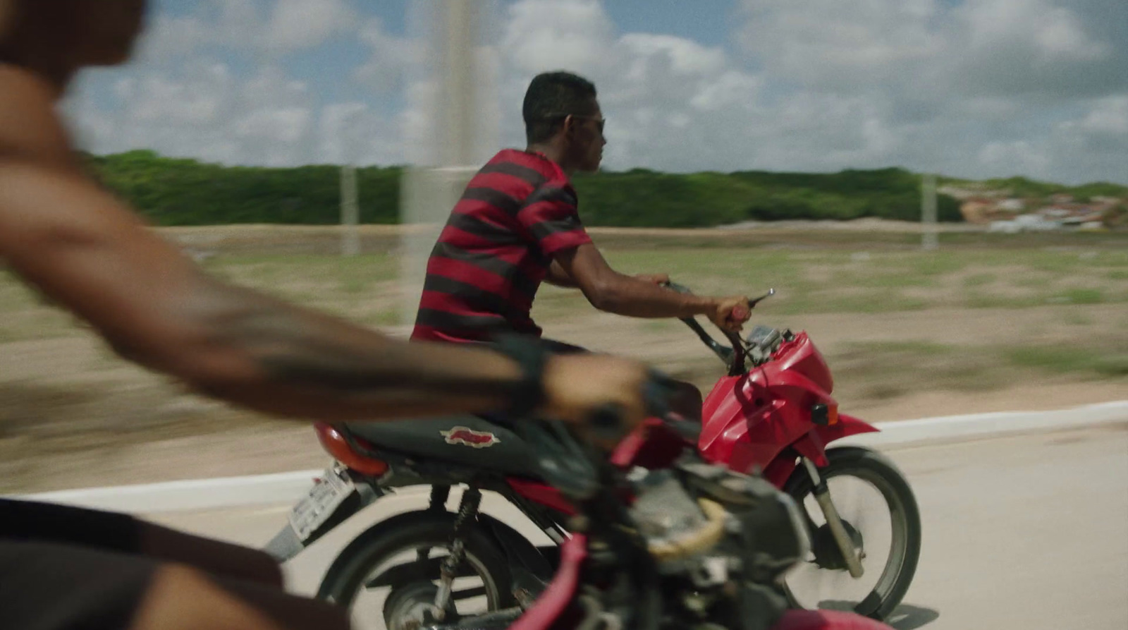 a man riding on the back of a red motorcycle