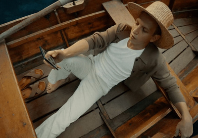 a man in a straw hat sitting on a wooden boat