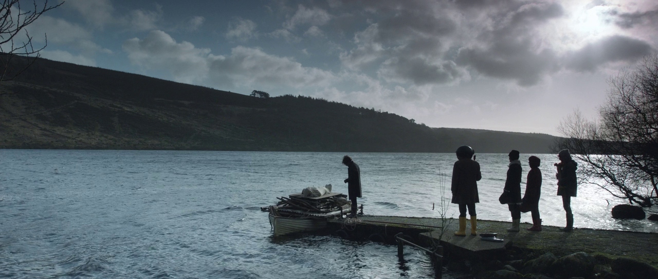 a group of people standing on a dock next to a body of water