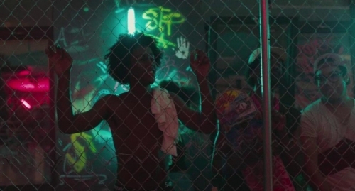 a group of people standing behind a chain link fence