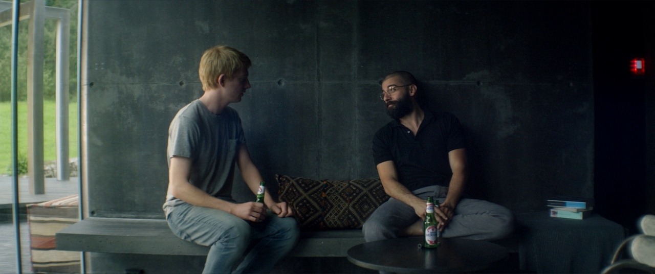 two men sitting on a bench talking to each other