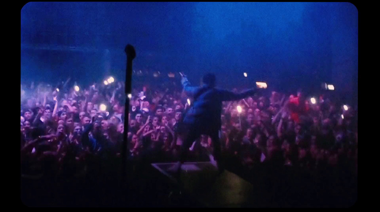 a man standing on top of a stage in front of a crowd