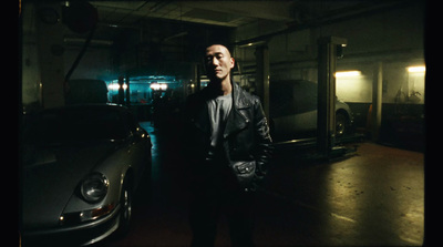 a man standing next to a car in a garage