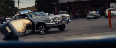 a car driving down a street next to a crowd of people