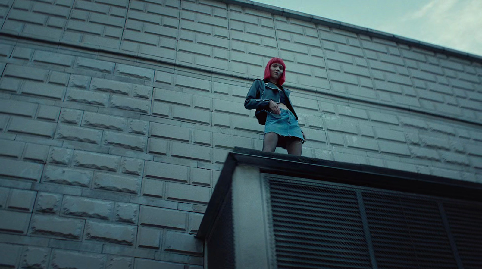 a woman standing on top of a building next to a window