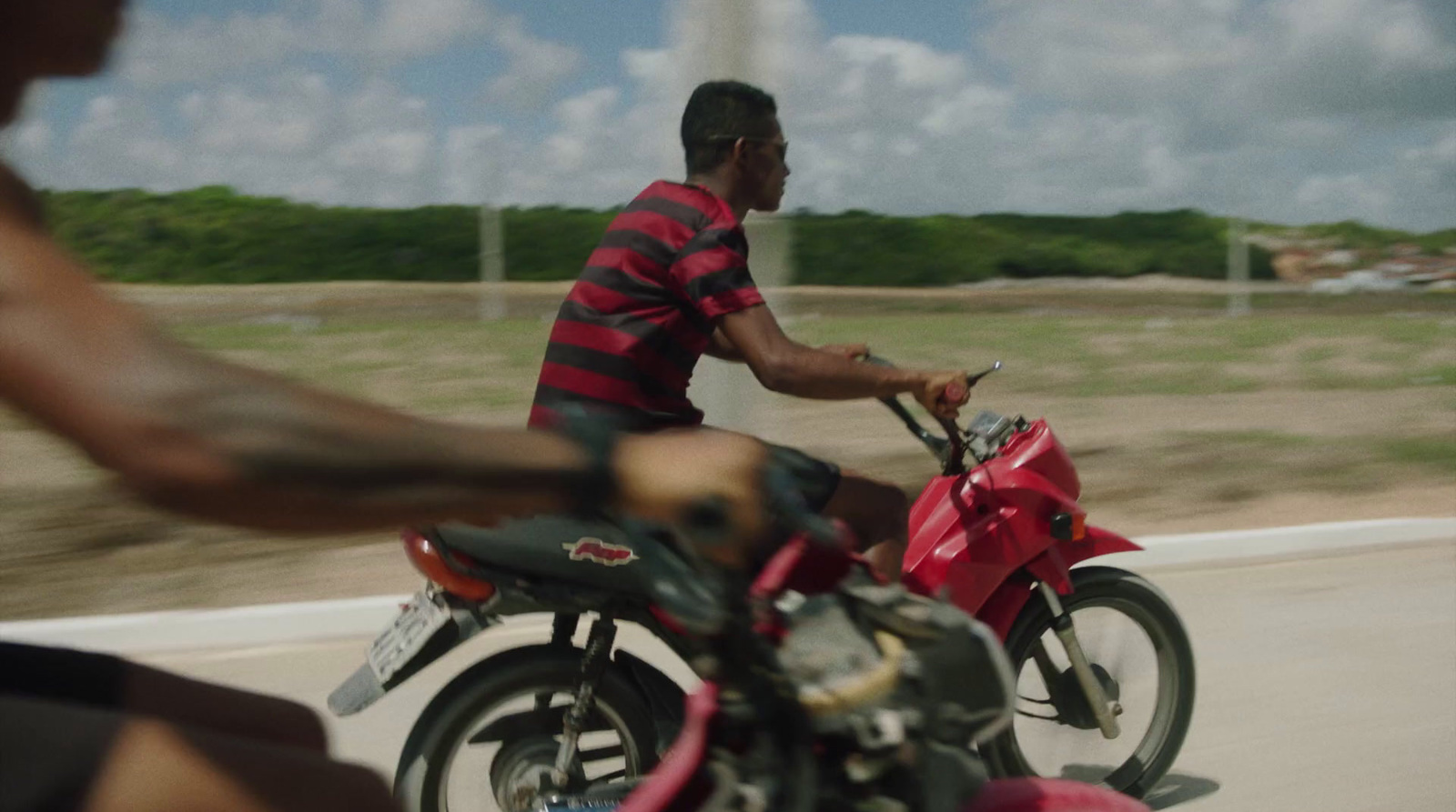 a man riding on the back of a red motorcycle