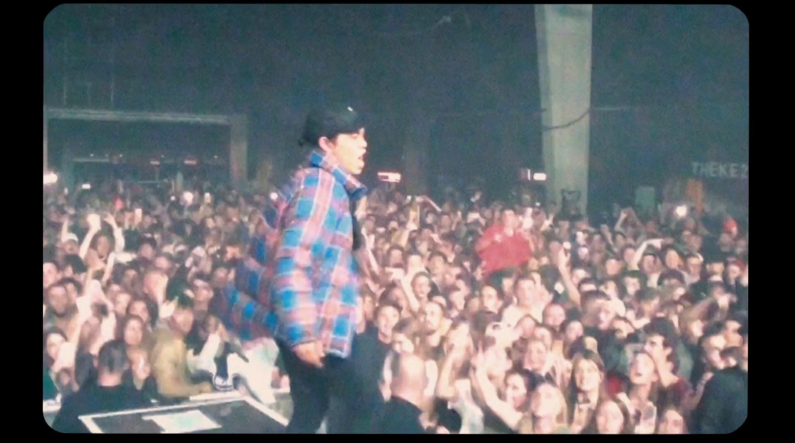 a man standing on top of a stage in front of a crowd