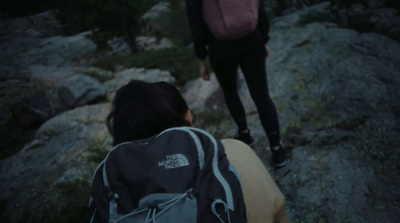 a person with a backpack walking up a hill