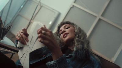 a woman sitting on a couch holding a piece of paper