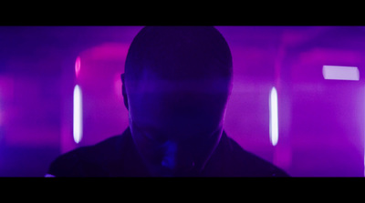 a man in a dark room with purple lights