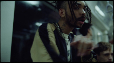 a man with dreadlocks standing on a subway