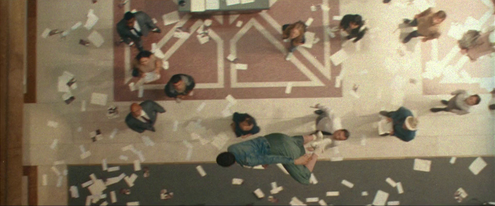 a group of people standing around a room filled with papers