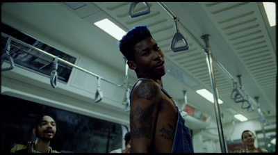 a man with tattoos standing in a subway car