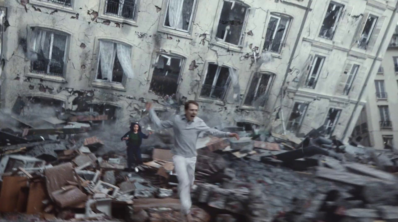 a man standing in front of a destroyed building