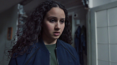 a woman with curly hair standing in a bathroom