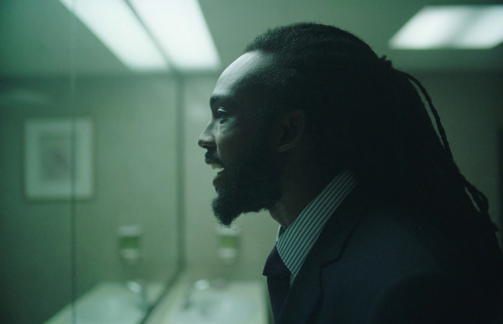 a man with dreadlocks standing in a bathroom