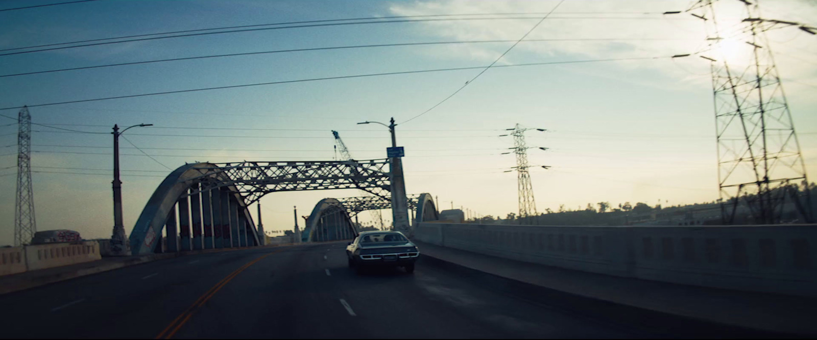 a car driving down a highway next to power lines