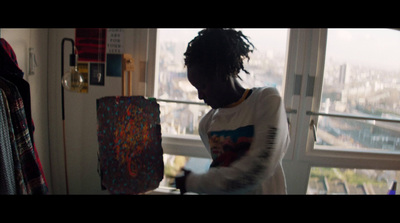 a woman holding a piece of art in front of a window