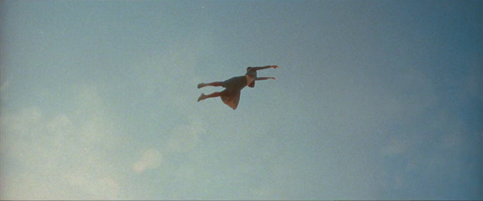 a man flying through the air on top of a kite