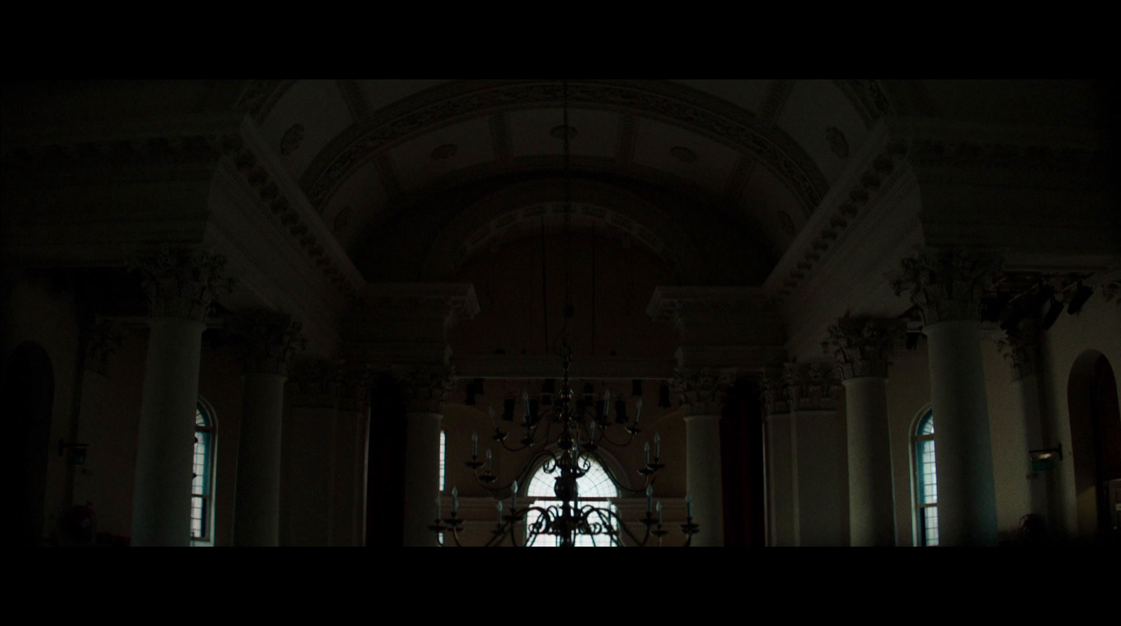 a dark room with a chandelier and chandelier hanging from the ceiling