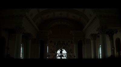 a dark room with a chandelier and chandelier hanging from the ceiling