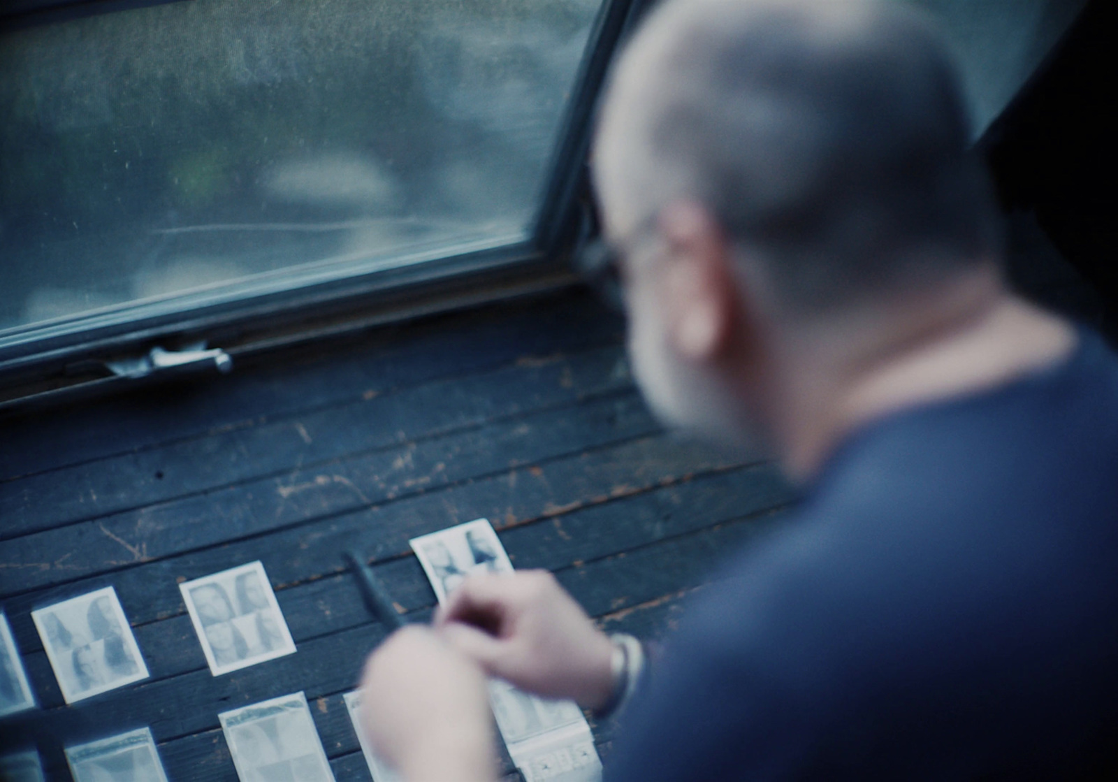 a man holding a piece of paper next to a window