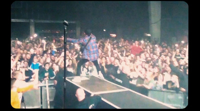 a man standing on top of a stage in front of a crowd