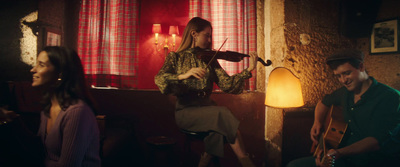 a woman playing a violin while a man plays a guitar