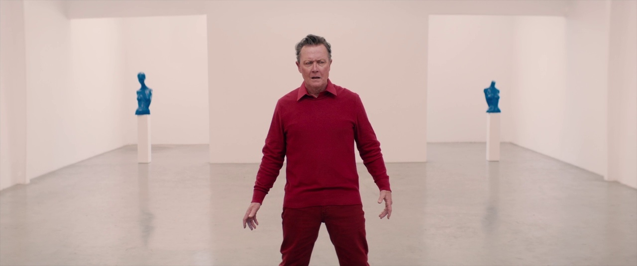 a man in a red shirt standing in a white room