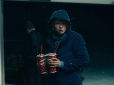 a man in a blue coat is holding a drink