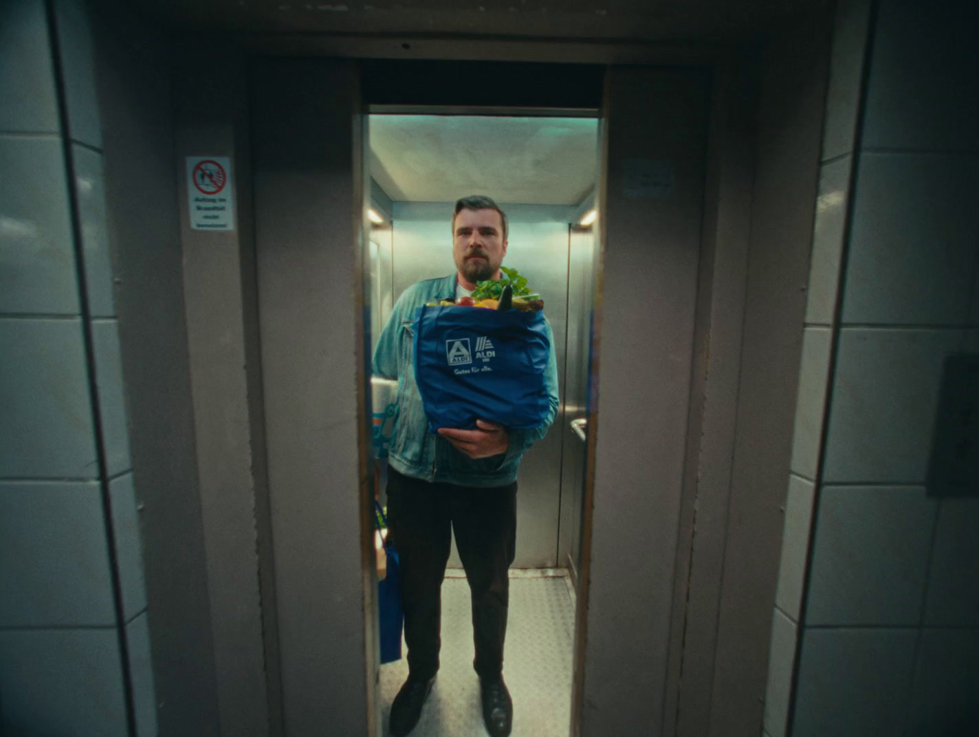 a man standing in a bathroom holding a bag of food