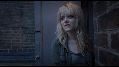 a woman standing in front of a brick wall