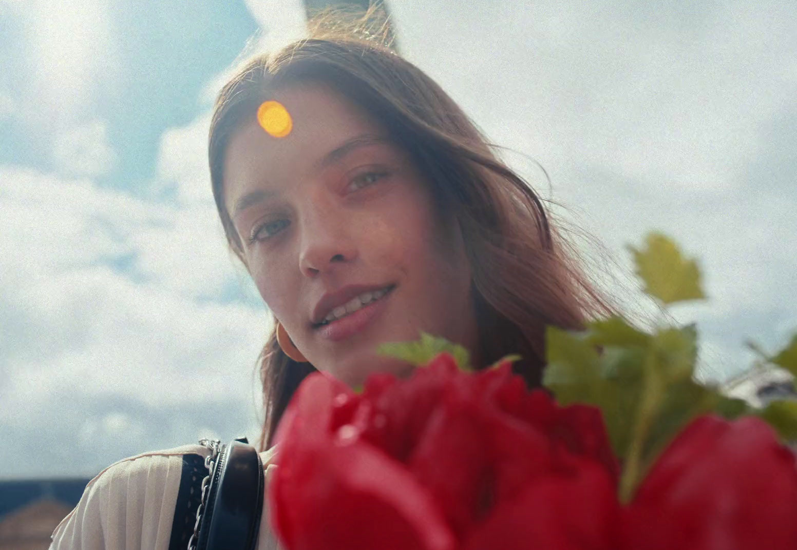 a woman holding a bunch of red flowers