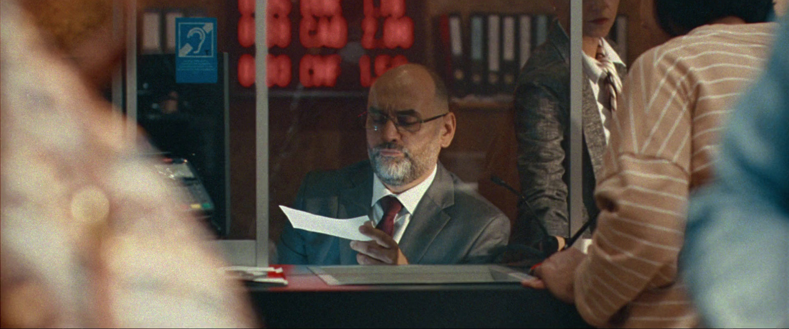 a man sitting at a desk in front of a window