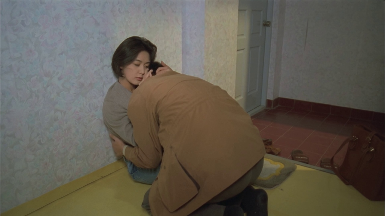 a man kneeling down next to a woman in a bathroom