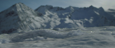 a snowboarder is going down a snowy mountain