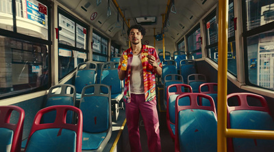 a man standing on a bus next to blue seats